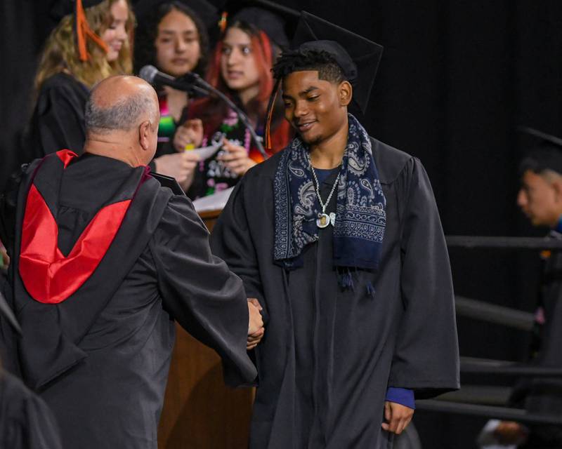 A DeKalb High School graduate accepts his diploma during the graduation ceremony on Saturday May 23, 2026, held at the Convocation Center in DeKalb.