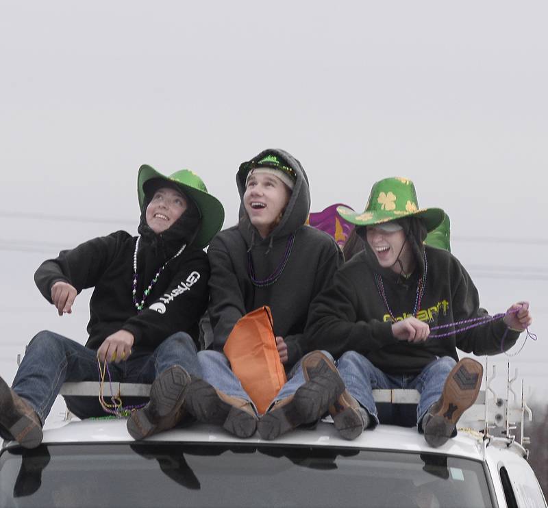 Sitting atop the Bruce & Ollie’s float, these boys toss beads to the crowd Saturday, Feb. 18, 2023, along Mill Street in Utica during the annual Mardi Gras parade.