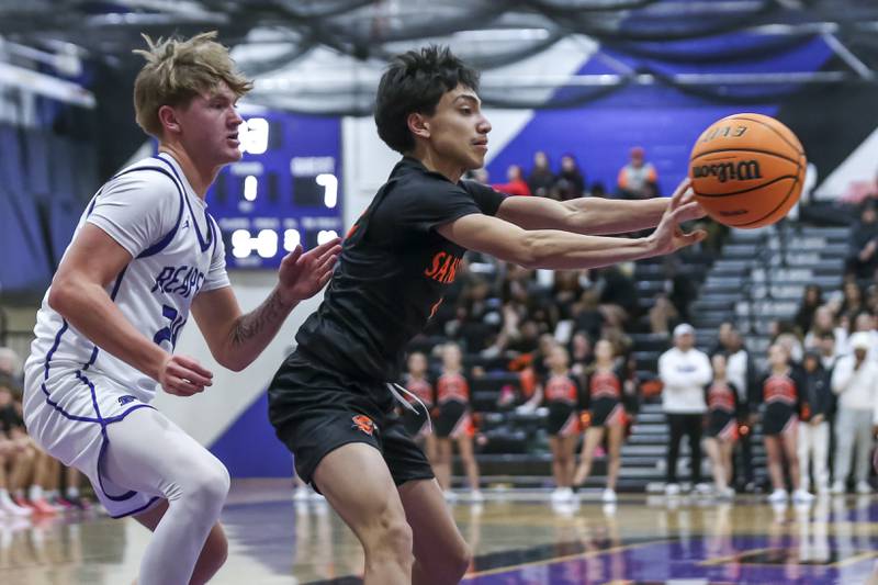 Sandwich's Eddie Ramirez (0) dishes a pass to the corner off of a drive to the basket during their basketball game between Sandwich at Plano Tuesday, Dec 9, 2025 in Plano.