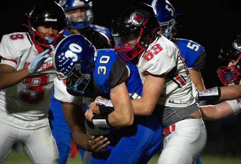 Clifton Central's Everett Bailey, center left, carries the ball on a play as Momence's Jackson Ford makes the tackle in a game on Friday, September 5, 2025.
