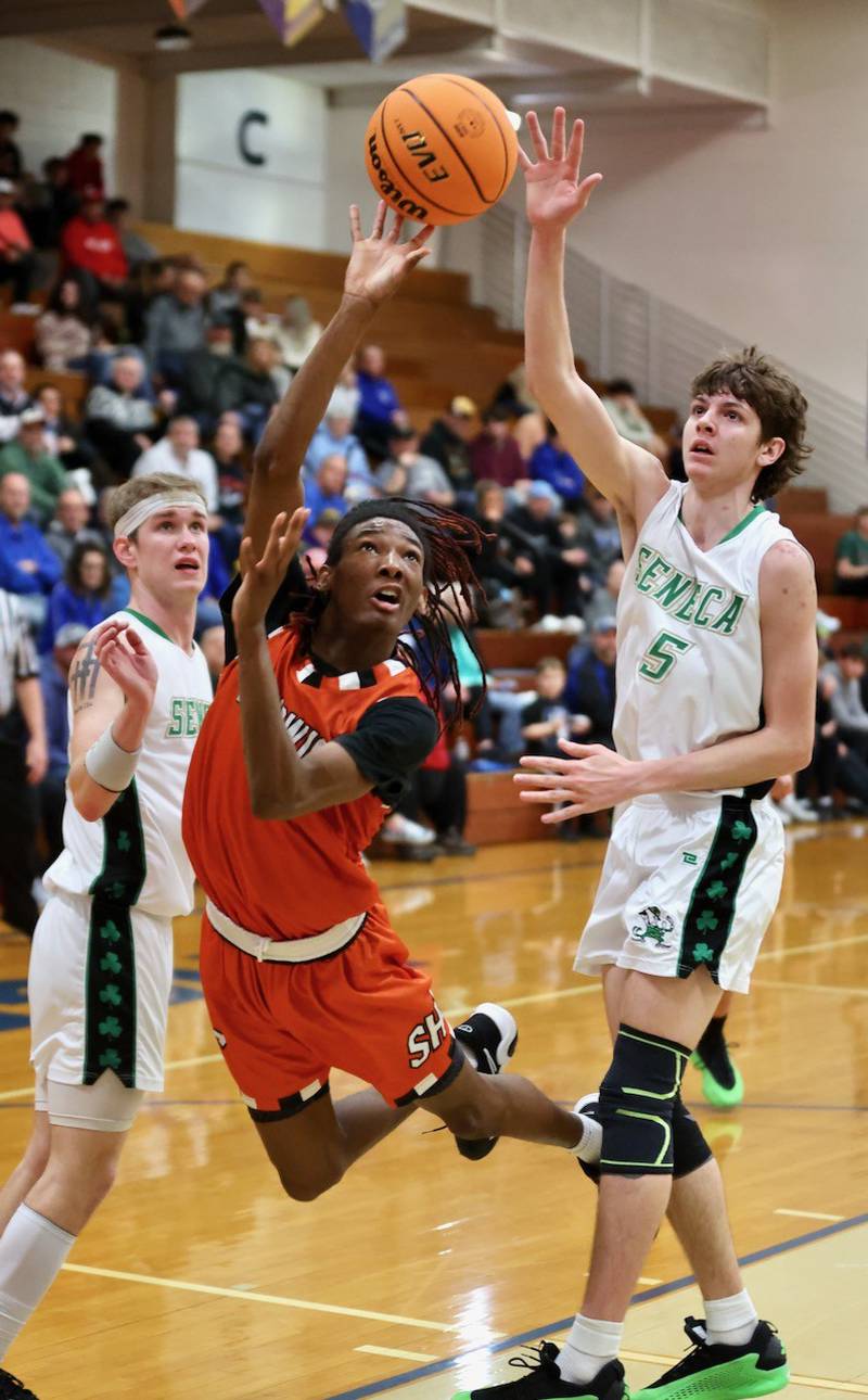 Sandwich's Simeion Harris twists and shoots between Seneca's Paxton Giertz (left) and Sebastian Deering in Wednesday's regional semifinal game at Princeton. The Irish pulled away for a 74-59 win.
