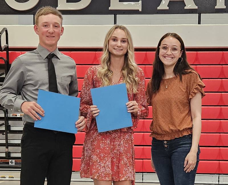 Madison Darm presents the SOCU Scholarship to Dylan Jenkins and Cloee Johnston.