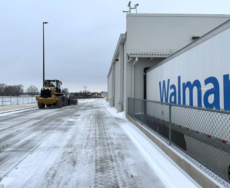 A large end loader plows snow behind the Sterling Walmart on Wednesday, Feb. 12, 2025.