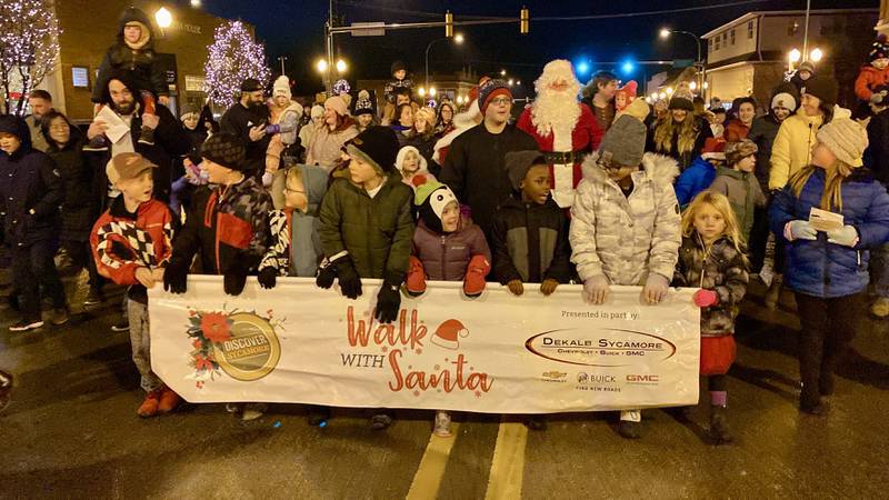 Children and families excited to meet the man from the North Pole marched along State Street with Santa Claus and Mrs. Claus in downtown Sycamore for Discover Sycamore's annual Walk with Santa on Friday, Dec. 1, 2023.
