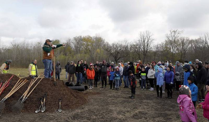 Forest Preserve District of Kane County Executive Director Benjamin Haberthur speaks to volunteers who were there plant 500 trees in honor of Earth Day Saturday at Tekakwitha Woods Forest Preserve in St. Charles.