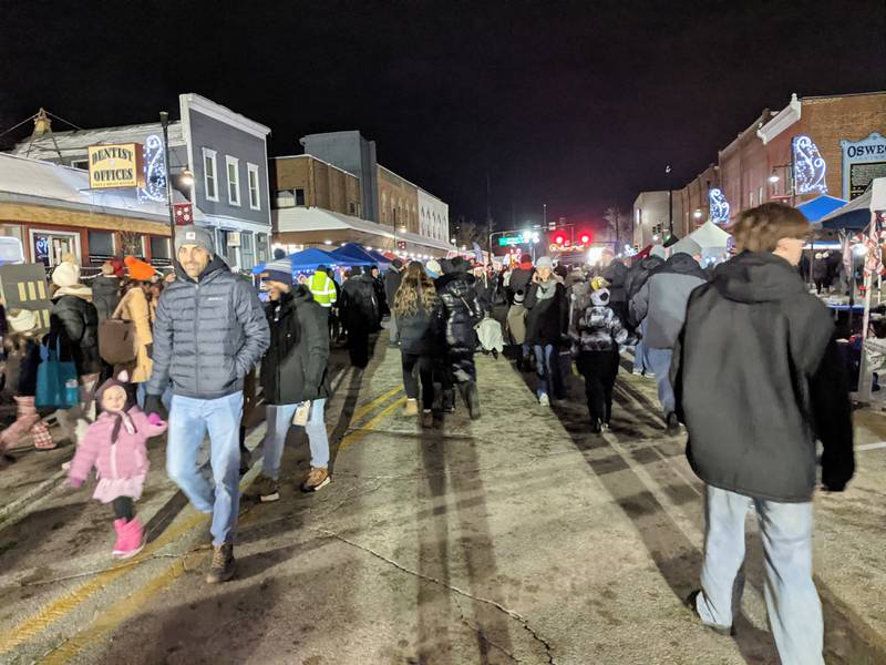 A crowd of people walk along Main Street in downtown Oswego during the Oswego Christmas Walk on Friday, Dec. 5, 2025.