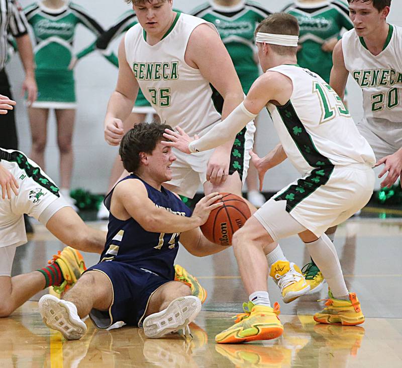 Marquette's Alex Graham is called for traveling on this play as he looks to pass the ball off against Seneca during the Tri-County Conference championship game on Friday, Jan. 27, 2023 at Putnam County High School.
