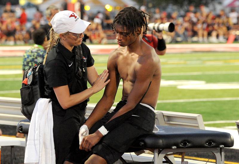 Yorkville receiver Dyllan Malone gets his shoulder checked by a trainer during a varsity football game against New Trier at Yorkville High School on Friday, Sep. 1, 2023.