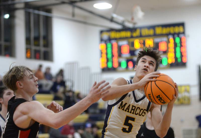 Polo's Gus Mumford (5) looks to the basket as he tries to avoid Earlville's Adam Waite (14) on Monday, Feb. 10, 2025 at Polo High School.
