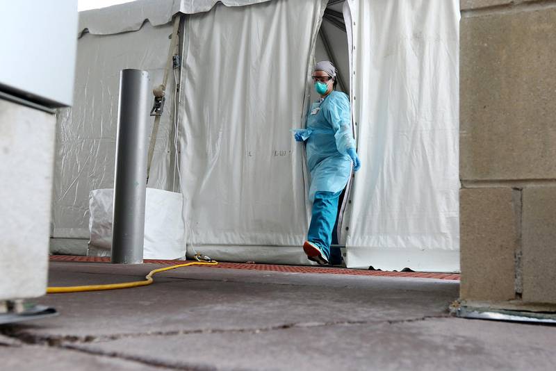 Employees at Northwestern Medicine Huntley Campus tend to a long line of vehicles at the 8 a.m. opening of its COVID-19 testing site on Tuesday in Huntley.