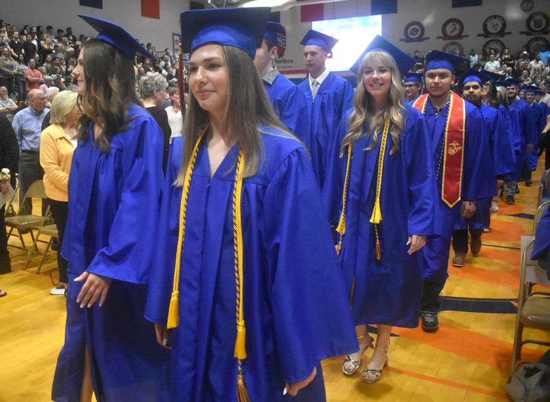 Genoa-Kingston seniors Annie Hughes, Lucy Foss, and Nora Foss walk with their classmates during the processional Saturday, May 17, 2025, during graduation at the school.