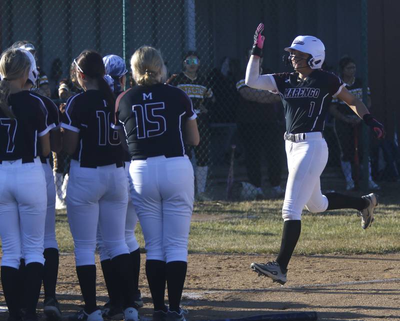 Marengo's Gabby Christopher is greeted by her teammates after hitting a home run during a nonconference softball game against Jacobs on Monday, March 9, 2026, at Marengo High School.