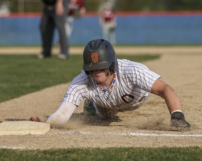 Oswego's Easton Ruby (2) dives back to first on a pick off attempt during baseball game between Plainfield North at Oswego, Thursday, April 24, 2025 in Oswego.