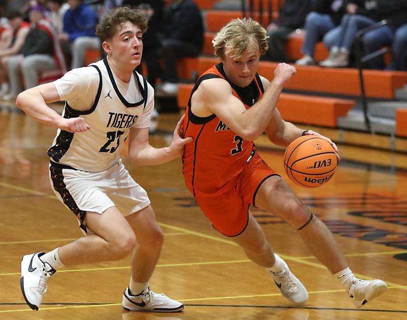 McHenry's Dane Currie (right) drives to the basket against Crystal Lake Central's Logan Laudadio during a Fox Valley Conference boys basketball game on Tuesday, February. 10, 2026, at Crystal Lake Central High School.