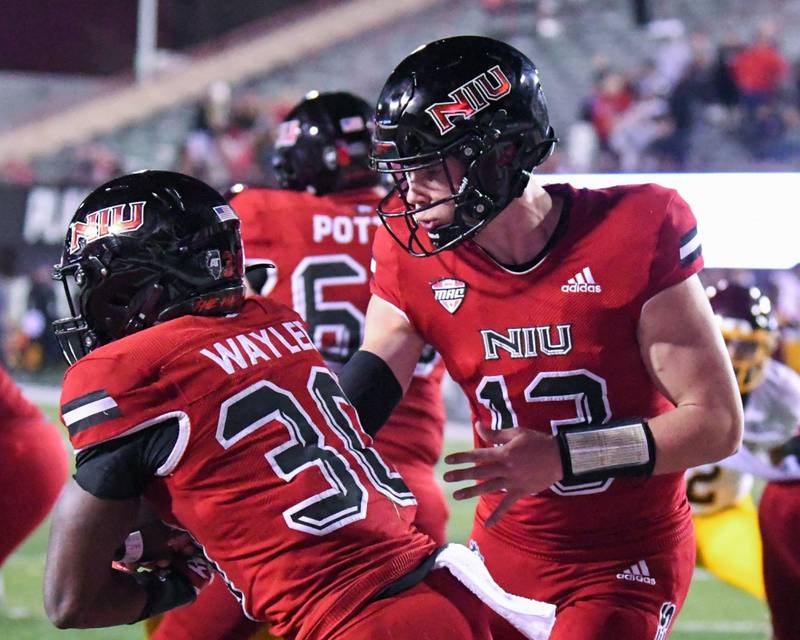 NIU quarter back Nevan Cremascoli, right, hands off the ball to running back Harrison Waylee, (30) as Northern Illinois tries to gain yards during the fourth quarter while taking on Central Michigan on Wednesday Nov. 2nd at Huskies Stadium in DeKalb.