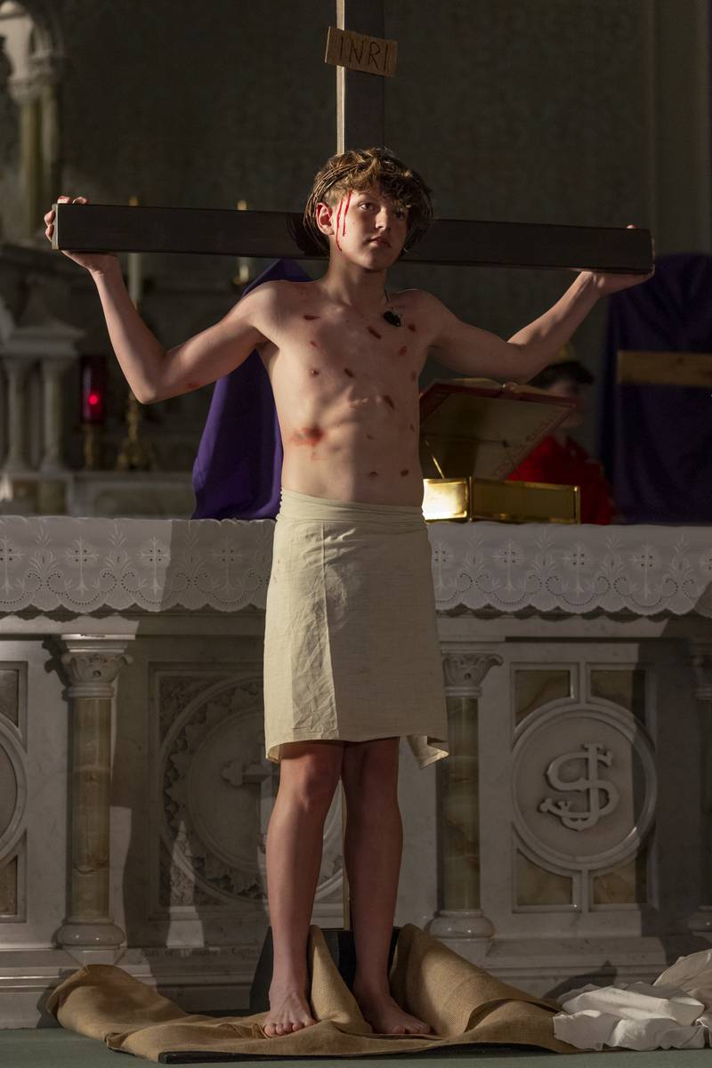 Bruno Baker portraying the role of Jesus demonstrates the crucifixion during the Stations of The Cross event on April 16, 2025 at St. Patrick's Church.