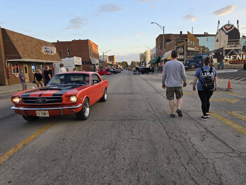 A classic car makes its way past car show goers Saturday, Sept. 21, 2024, during the Seneca Cruise Night on Main Street.