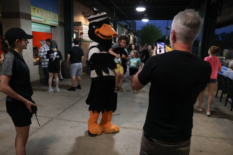 Lucas, of Joliet, takes a photo of his daughter Harper with J.L. Bird, the Joliet Slammers mascot at the home opener against the Ottawa Titans. Friday, May 13, 2022, in Joliet.