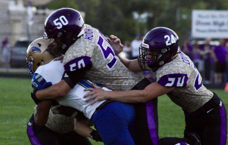 Dixon's Aidan Hoggard (5) and Hunter Vacek (24) bring down a Rockford Christian ball carrier.