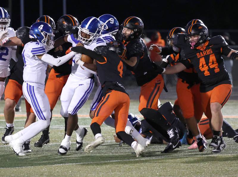 Phillips' Ameen Robinson is brought down by a host of DeKalb defenders Friday, Sept. 5, 2025, during their game at DeKalb High School.