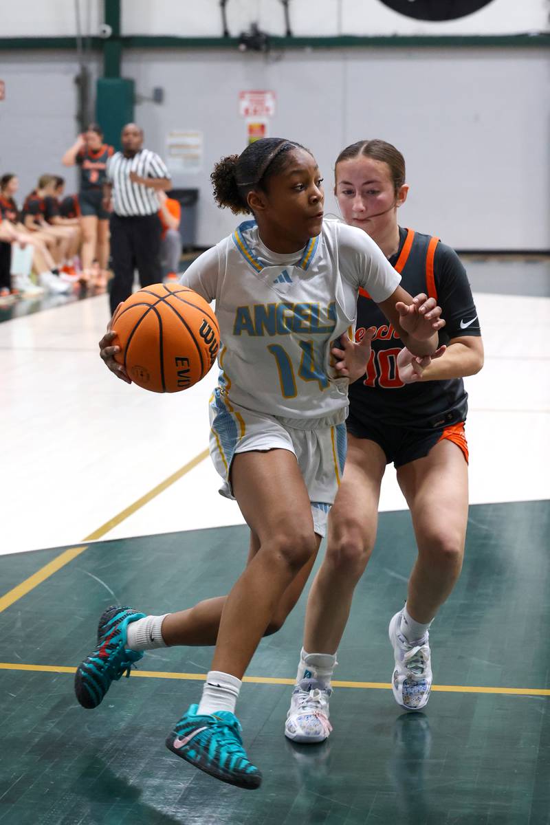 Joliet Catholic's Laylah Carroll drives to the lane against Beecher's Olivia Rietveld during Joliet Catholic's 72-28 victory over Beecher in the IHSA Class 2A Bishop McNamara Regional semifinals on Monday, Feb. 16, 2026.