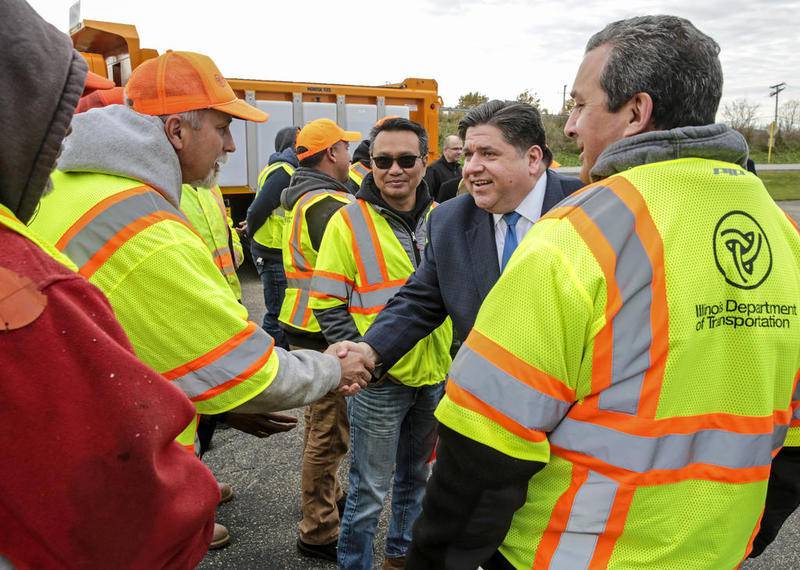 Gov. JB Pritzker shakes hands with Illinois Department of Transportation employees Wednesday in Plainfield.
