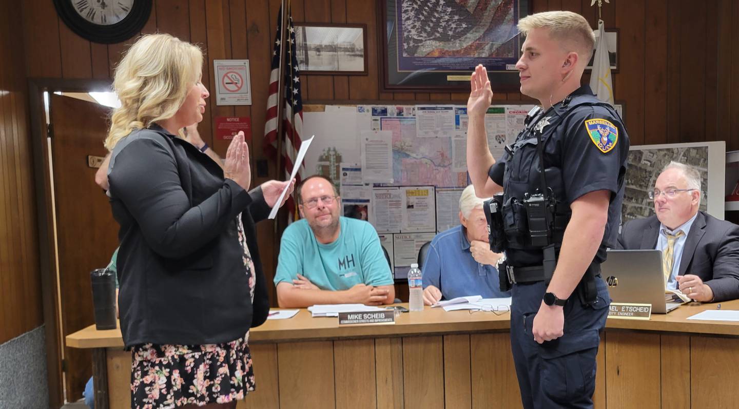 Marseilles Commissioner Melissa Small (left) swears in the city's newest police officer, Jacob Bakalik, at Wednesday's city council meeting.