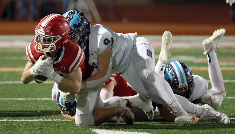 Naperville Central's Aiden Clark is brought down by Downers Grove South's Ethan Onusaitis (9) Friday October 27, 2023 in Naperville.