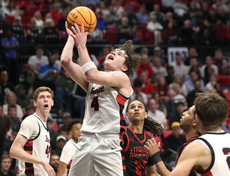 Benet's Ethan MacDermot drives through a pair of Auburn defenders Monday, March 9, 2026, during their IHSA Class 4A supersectional matchup in the Convocation Center at Northern Illinois University in DeKalb.
