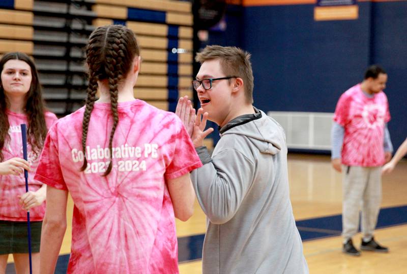 Wil Jarvis high-fives a classmate during a golf lesson in his physical education class at Oswego High School on Monday, March 4, 2024. The class was part of a six-week program collaboration with the U.S. Adaptive Golf Alliance.