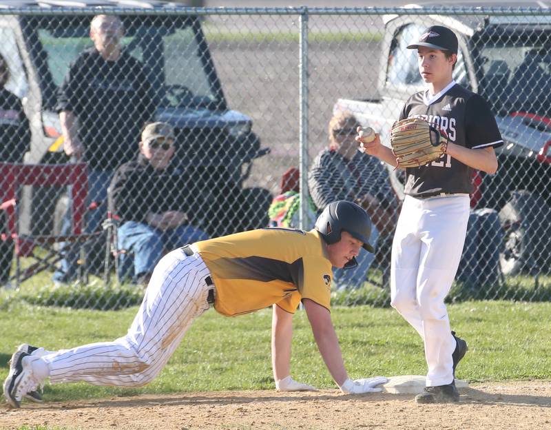 Putnam County's Jaden Stoddard dives back into third base as Woodland/Flanagan-Cornell's Reece Pelnarsh holds on to the ball on Tuesday, April 9, 2024 at Woodland High School.
