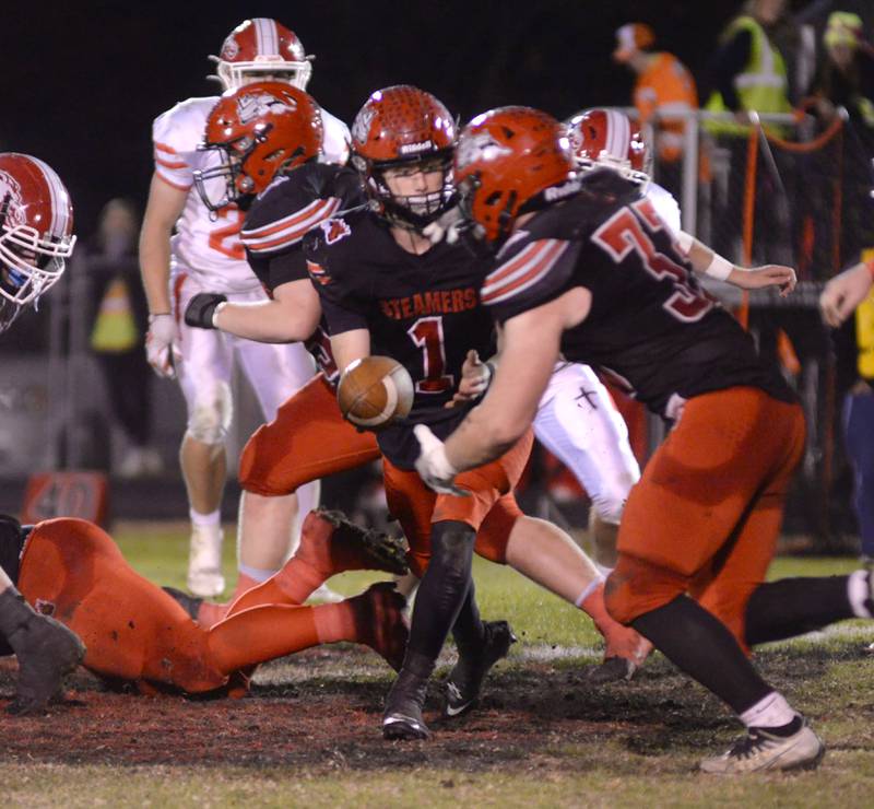 Fulton's Braedon Meyers (1) hands the ball to Skylier Crooks (33) during action against Morrison on Friday, Oct. 25, 2024 in Fulton.