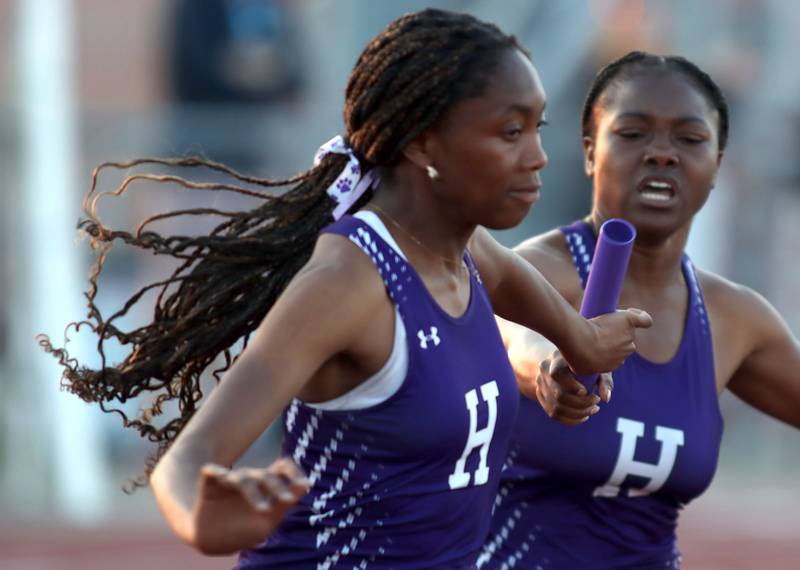 Hampshire’s Jmyra McCroy, right, hands off to teammate Malaya Ligon in the 800-meter relay in IHSA Class 3A Girls Sectional Track and Field Meet action at Red Raider Stadium on the campus of Huntley High School in Huntley on Wednesday, May 14, 2025.