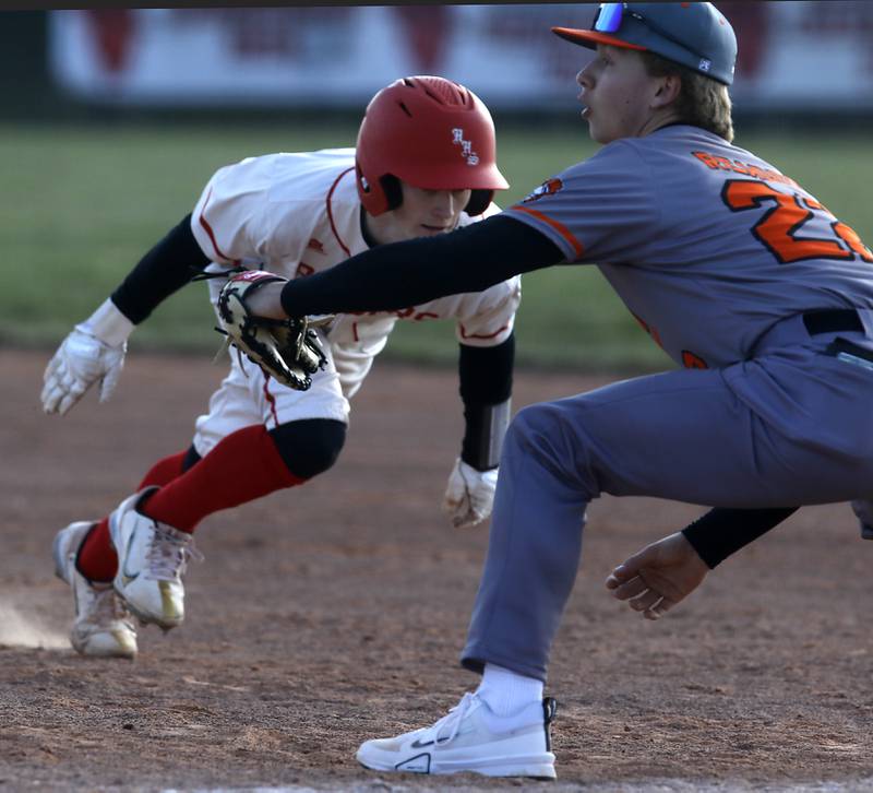 Huntley's Jack Ezell dives back to first base McHenry’s Zachary Readdy covers there bag during a Fox Valley Conference baseball game on Friday, April 11, 2025, at Huntley High School.