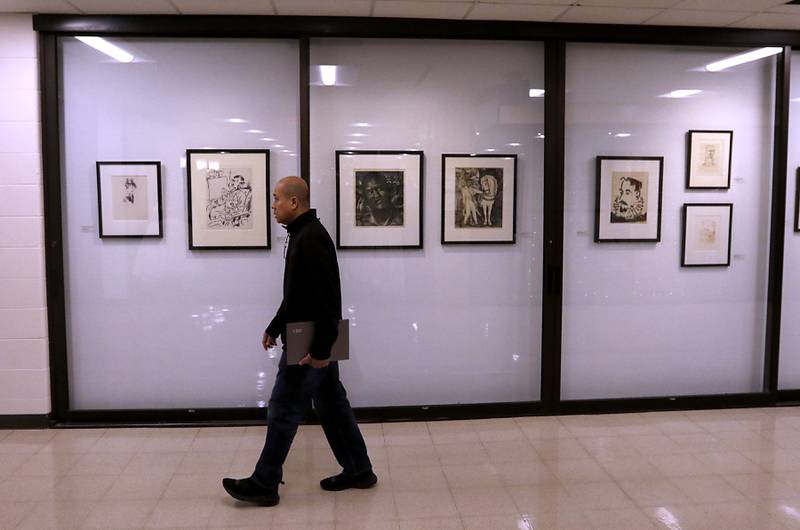 A man walks past the Iconic Impressions display in the Epping Gallery on Thursday, Feb, 6, 2025, at McHenry County College.