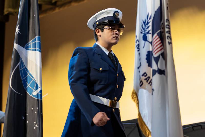 Edgar Rios walks across the stage after sharing the history of the Coast Guard during the Veterans Day Assembly at Joliet Central High School on Nov. 7, 2025.