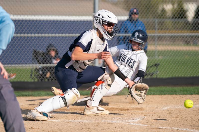 Oswego East's Mary Kate Quaid (8) beats the throw to home for a score against Oswego's Kiyah Chavez (left) during a softball game at Oswego East High School on Friday, April 21, 2023.