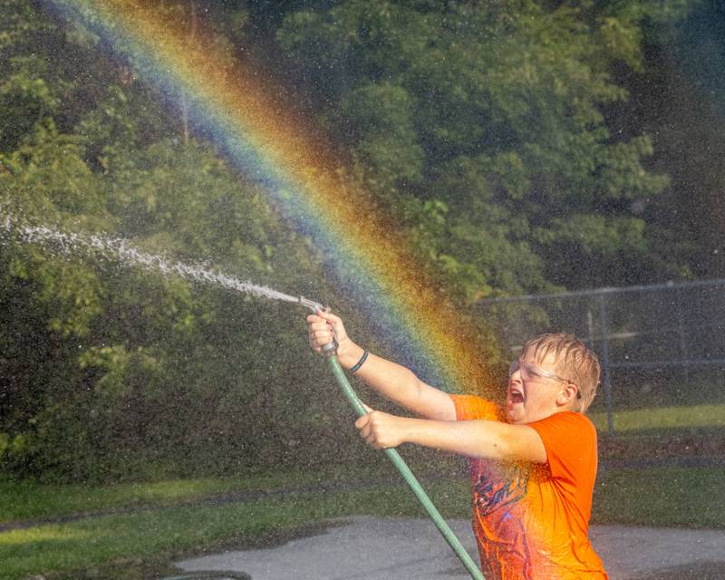 Easton Meador gets hit with water as he battles an opponent in the water tug-of-war event during National Night Out on Aug. 5, 2025, in Seneca.