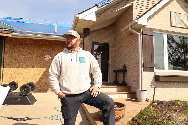 Cameron Gerth stands outside his home in the Oakwoods subdivision in Aroma Township on April 8, 2026, nearly one month after the EF-3 tornado.