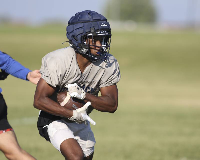 Jasiah Watson runs with the ball at Oswego East High School football practice, Monday, Aug 13, 2025 in Oswego.