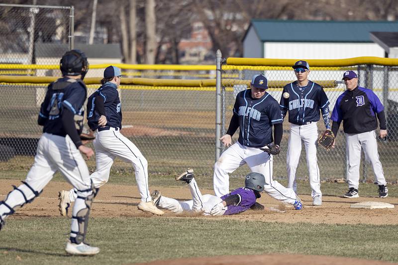 Dixon’s Alex Harrison dives back safely to first base after getting caught in a rundown Monday, March 20, 2023 against Rockford Guilford.
