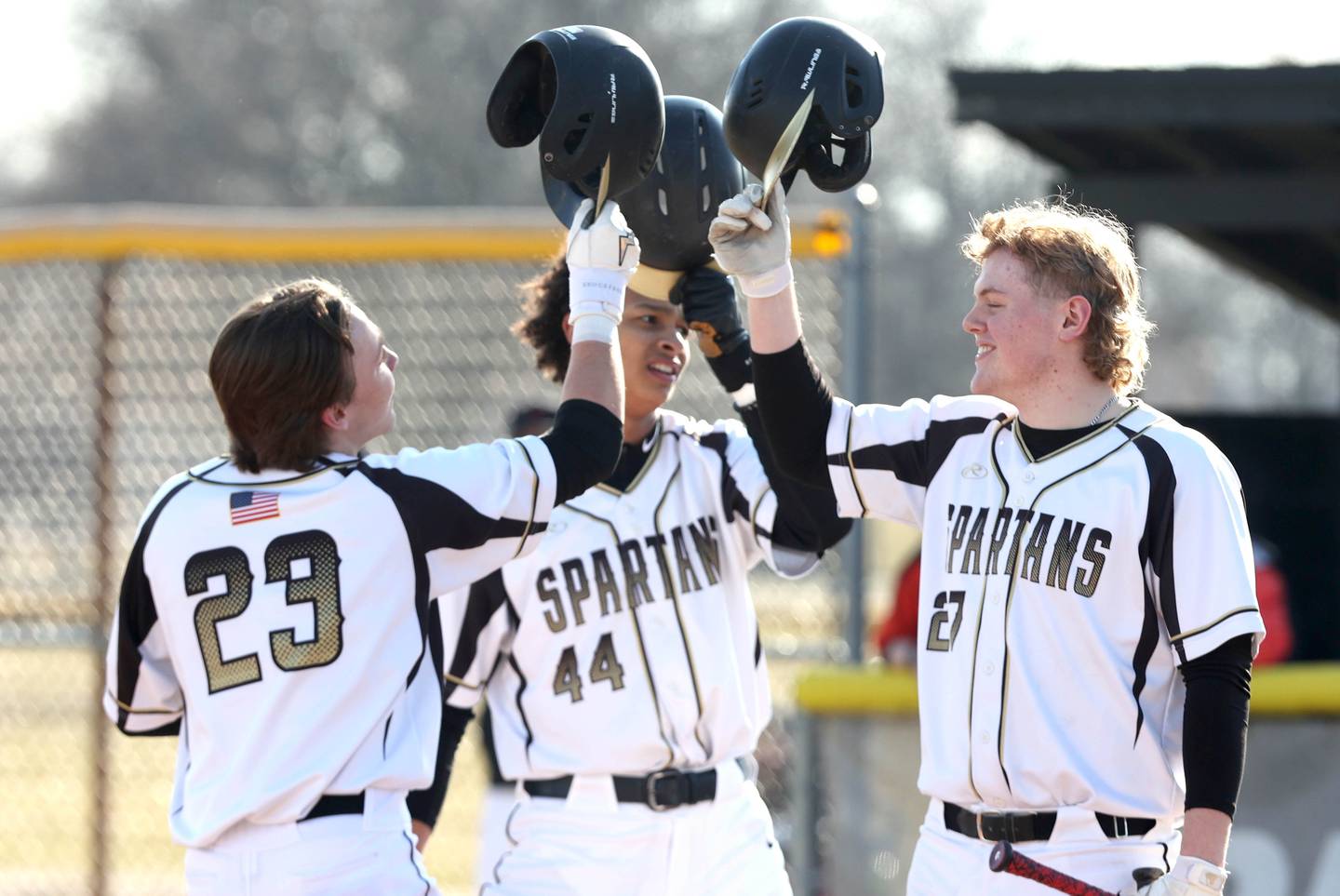Sycamore's Kyle Hartmann (left) is greeted by Tommy Townsend and Jimmy Amptmann (right) as he crosses the plate after hitting his first of three home runs during their game against Harlem Monday, March 27, 2023, at the Sycamore Community Park.