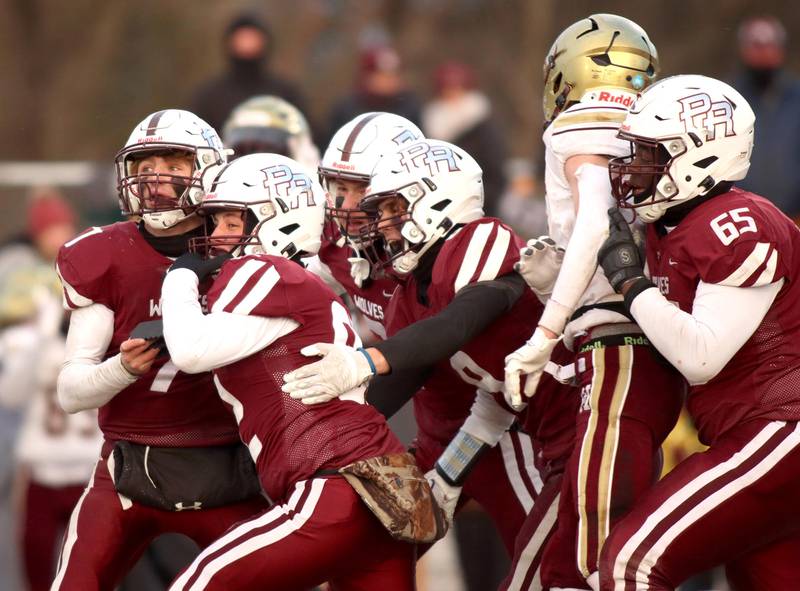 Prairie Ridge kicker Brogan Amherdt is mobbed by the Wolves as his field goal sealed a win over St. Ignatius in Class 6A football playoff semifinal action at Crystal Lake on Saturday.