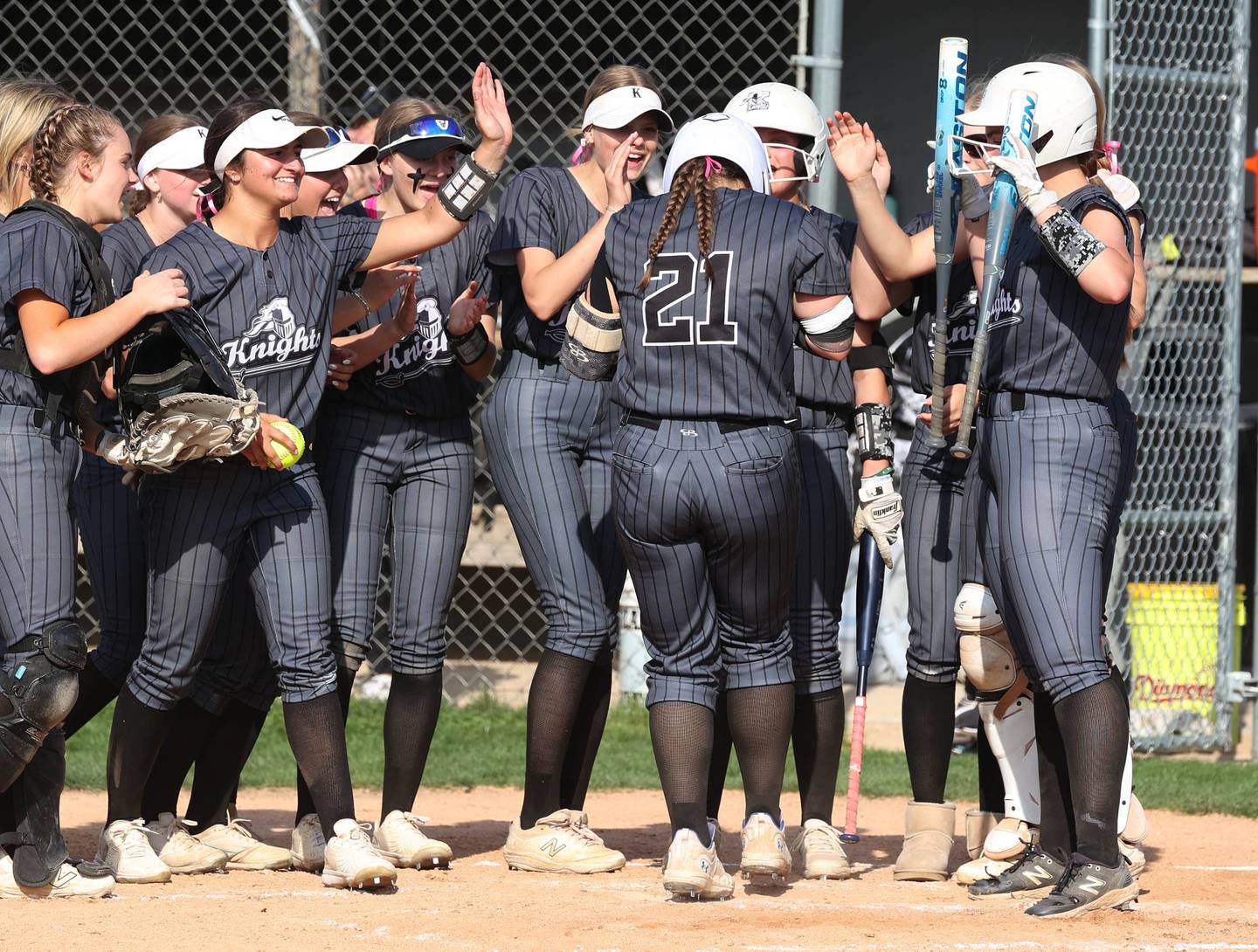 Kaneland's Addison Coulter is mobbed by her team as she touches home plate after homering during their game against Sycamore Wednesday, May 7, 2025, at Kaneland High School in Maple Park.