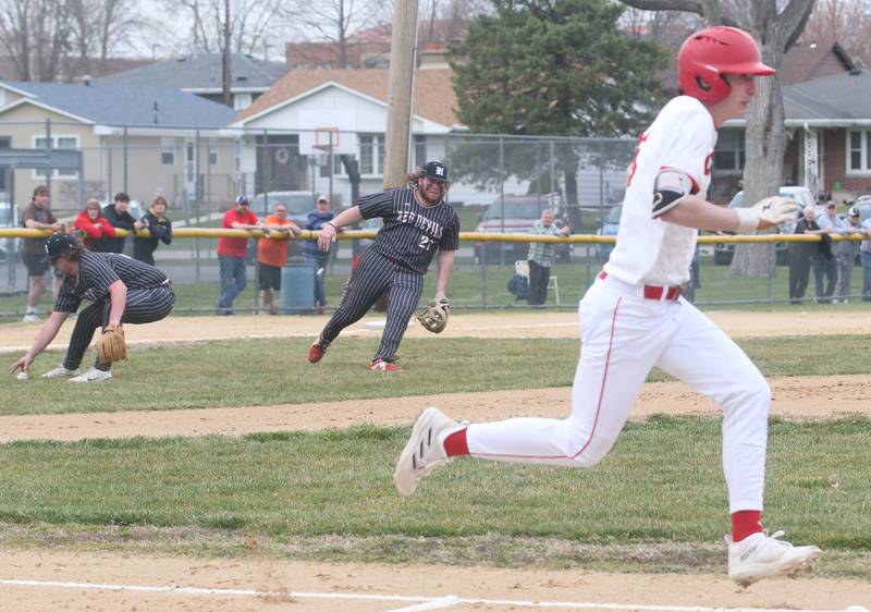 Hall's Payton Dye picks up a bunted ball as teammate Joel Koch backs away while Streator's Colin Byers sprints safely into first base on Wednesday, March 13, 2024 at Kirby Park in Spring Valley.