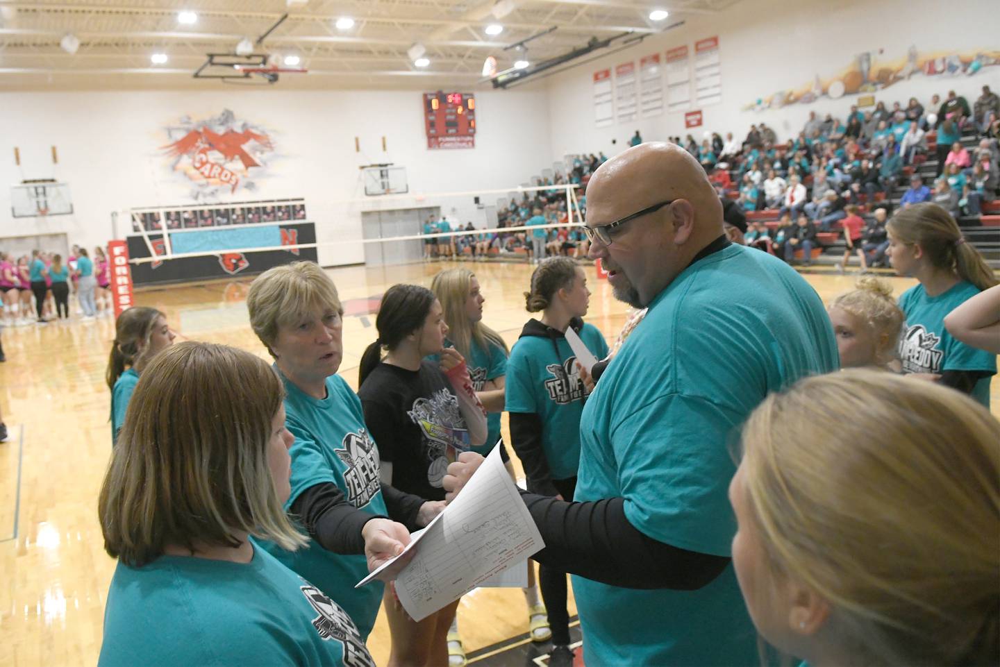 Forreston High School Principal Travis Heinz and other helpers read the silent auction winners during the "Team Leddy Family is Everything" Volley for the Cure volleyball game in Forreston against Milledgeville on Tuesday, Sept. 27. Leddy, a teacher in the Forrestville Valley School District who is a native of Milledgeville, is battling cancer. Tuesday night's event included a slient auction, bake sale, and t-shirt sales to aid her in her battle.