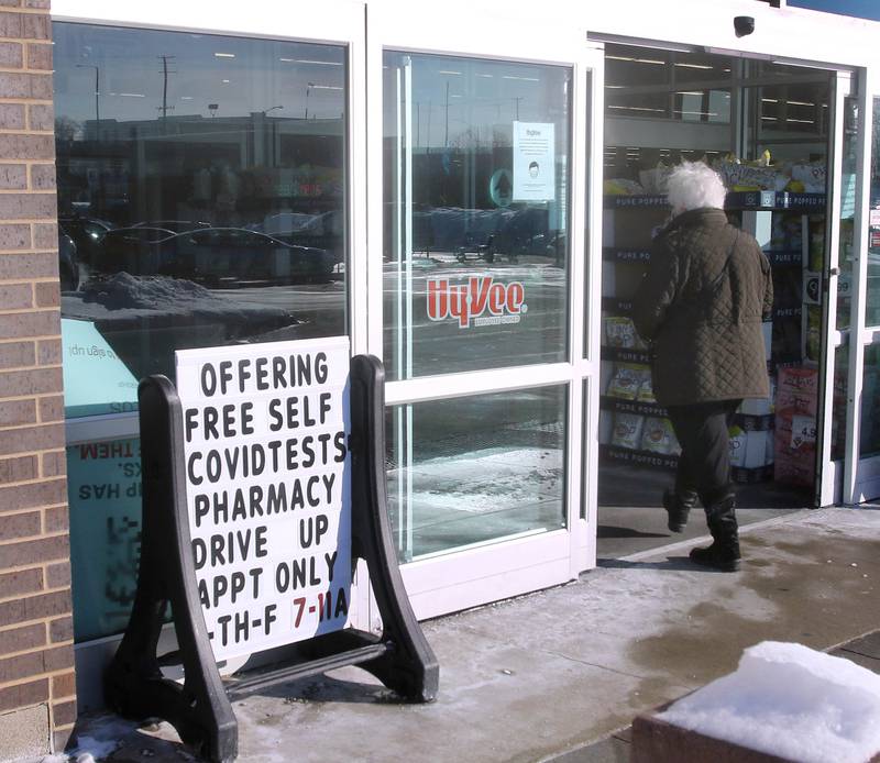 A customer enters the Hy-Vee on DeKalb Avenue in Sycamore next to a sign promoting their drive-thru COVID-19 testing.