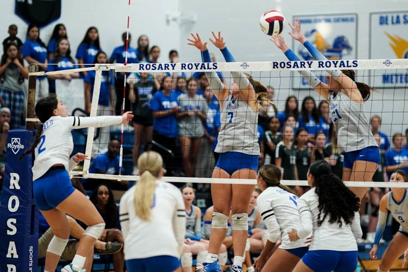 Rosary’s Charlotte Blankenheim (2) goes up for a kill attempt against St. Charles North's Mia McCall (7) and Brynn Hopkins (21) during a volleyball game at Rosary High School in Aurora on Monday, Aug 25, 2025.