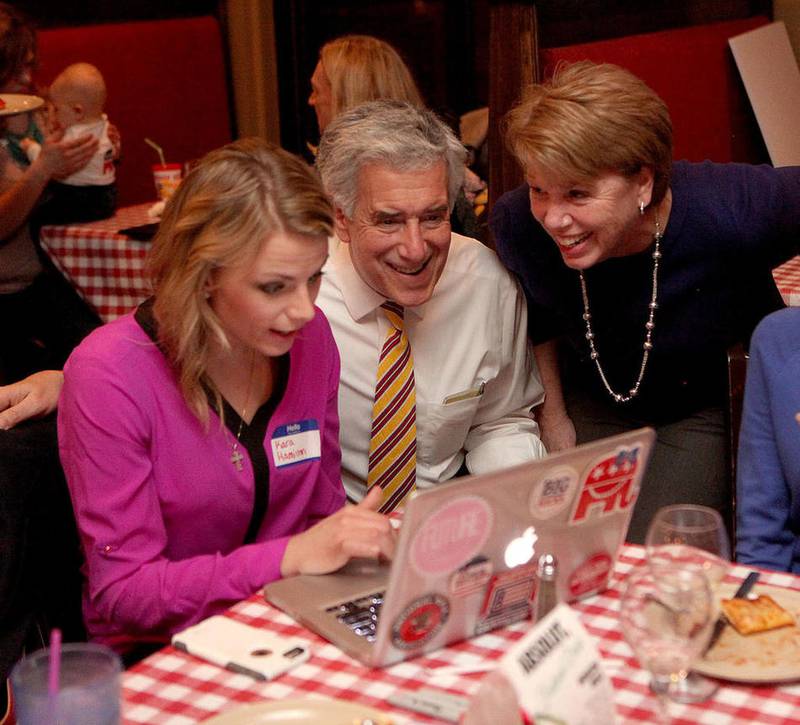 Kane County Chairman Chris Lauzen (second from left), running for re-election against challenger Ken Shepro, looks at election results with Kara Hamilton (left) and wife Sarah Lauzen Tuesday night at Aurelio's in Geneva.