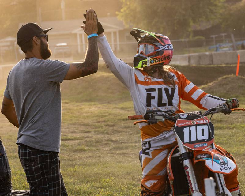 Motocross instructor Justin Kelly high fives student Juliann Walters after her race during Megacross at the Tri County Fair on August 30, 2025 in Mendota.